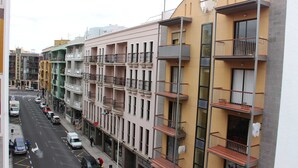 Ein mehrstöckiges Wohngebäude mit Balkonen und Blick auf die Straße.