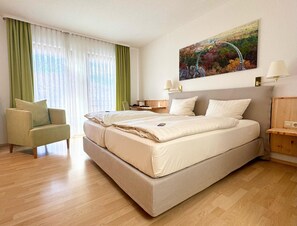 A hotel room with a large bed, a chair, a desk, and a painting on the wall. - Hotel-Restaurant Bastenhaus (Dannenfels)