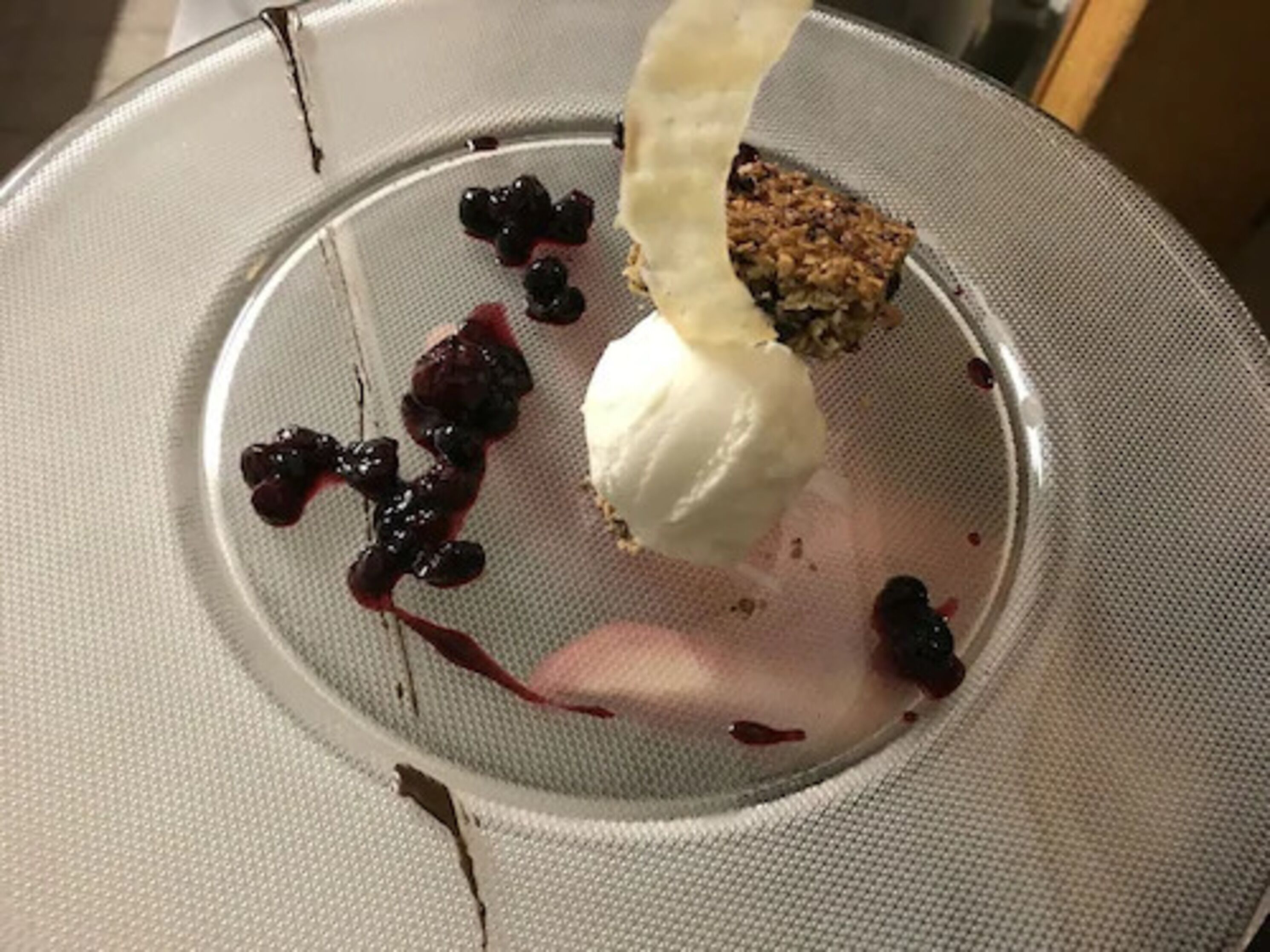 A dessert with ice cream and berries on a plate.