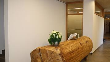A reception desk with a wooden finish and a potted plant.