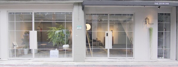 A building with large windows, a sign reading "THE DOOR INN", and a visible door.