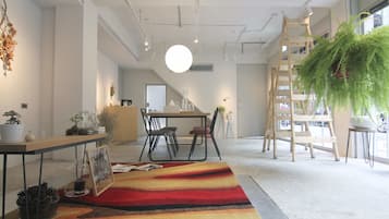 Un interior moderno con comedor, escalera y plantas en macetas.
