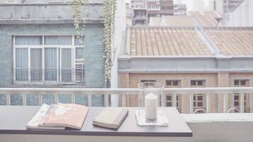 A balcony with a table holding books and a candle holder.