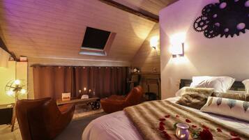 Une chambre confortable avec un grand lit, un bureau et une chaise. Il y a une fenêtre et un élément décoratif sur le mur.