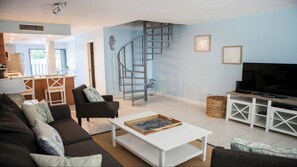 Relax in this stylish living room with a sofa, coffee table, and large flat-screen TV.