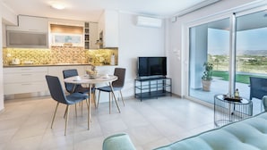 Une cuisine moderne avec un coin repas, un téléviseur et un balcon offrant une vue agréable.