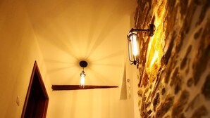 Una scala con ringhiera in legno e un lampadario a parete.