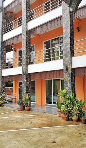 A multi-story building with balconies, stone pillars, and potted plants. - B and B Hotel (Ranong)