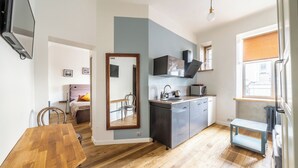 Un espacio habitable compacto con kitchenette, comedor y una pequeña zona de estar.