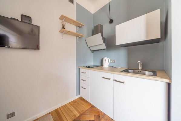 A compact kitchen with a built-in oven, a sink, and a small countertop.