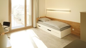 Une chambre à coucher moderne avec un lit, une chaise et un bureau.