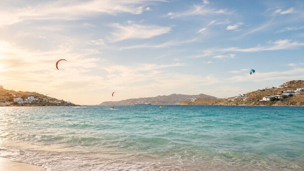A beach with clear water, a sandy shore, and distant hills. - Eleftheria Hotel (Mykonos)