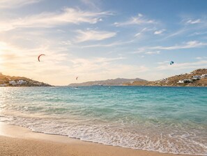 A beach with clear water, a sandy shore, and distant hills. - Eleftheria Hotel (Mykonos)