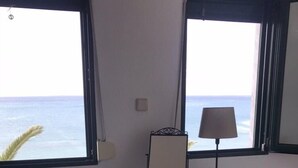 A room with a desk, a lamp, and a view of the ocean. - Stunning sea-front maisonette (Kassandra)
