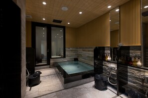 Relax in a spacious bathroom with a large bathtub and glass-enclosed shower.