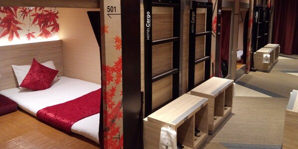Relax in a cozy space with a neatly made bed and a wooden bench for seating.