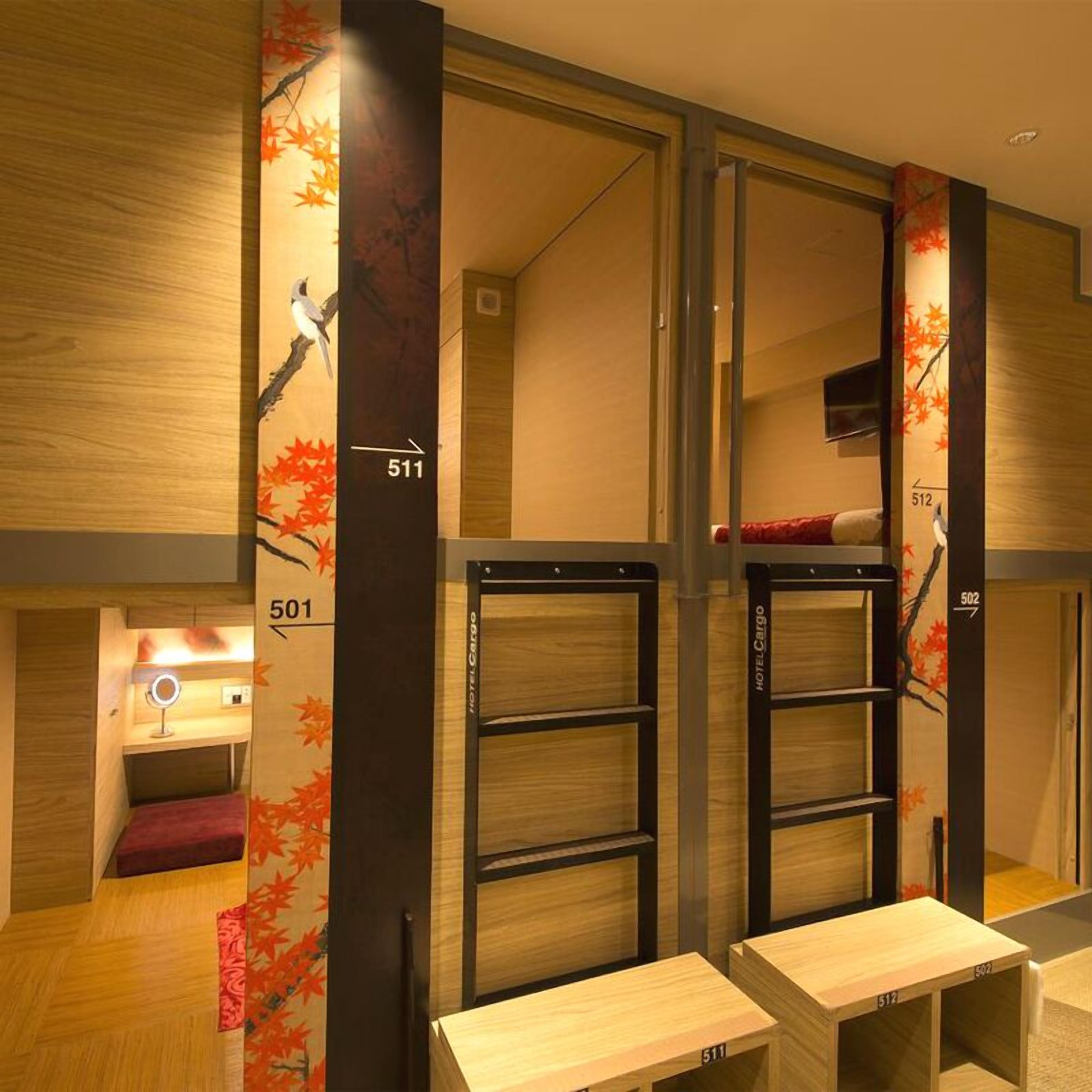 A hotel room with a bunk bed, a small desk with a mirror, and a wall with numbers indicating room positions.