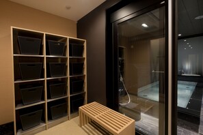 Experience a contemporary bathroom with a large shower, shelving, and a comfortable bench.