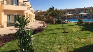 Un resort con varias edificaciones, una piscina y céspedes bien cuidados.