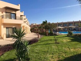 A resort with multiple buildings, a swimming pool, and well-maintained lawns.