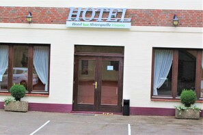 Hotel Alsterquelle Eingang features a traditional facade with a brick upper section and a cream-colored lower section, complete with large windows and a welcoming entrance.