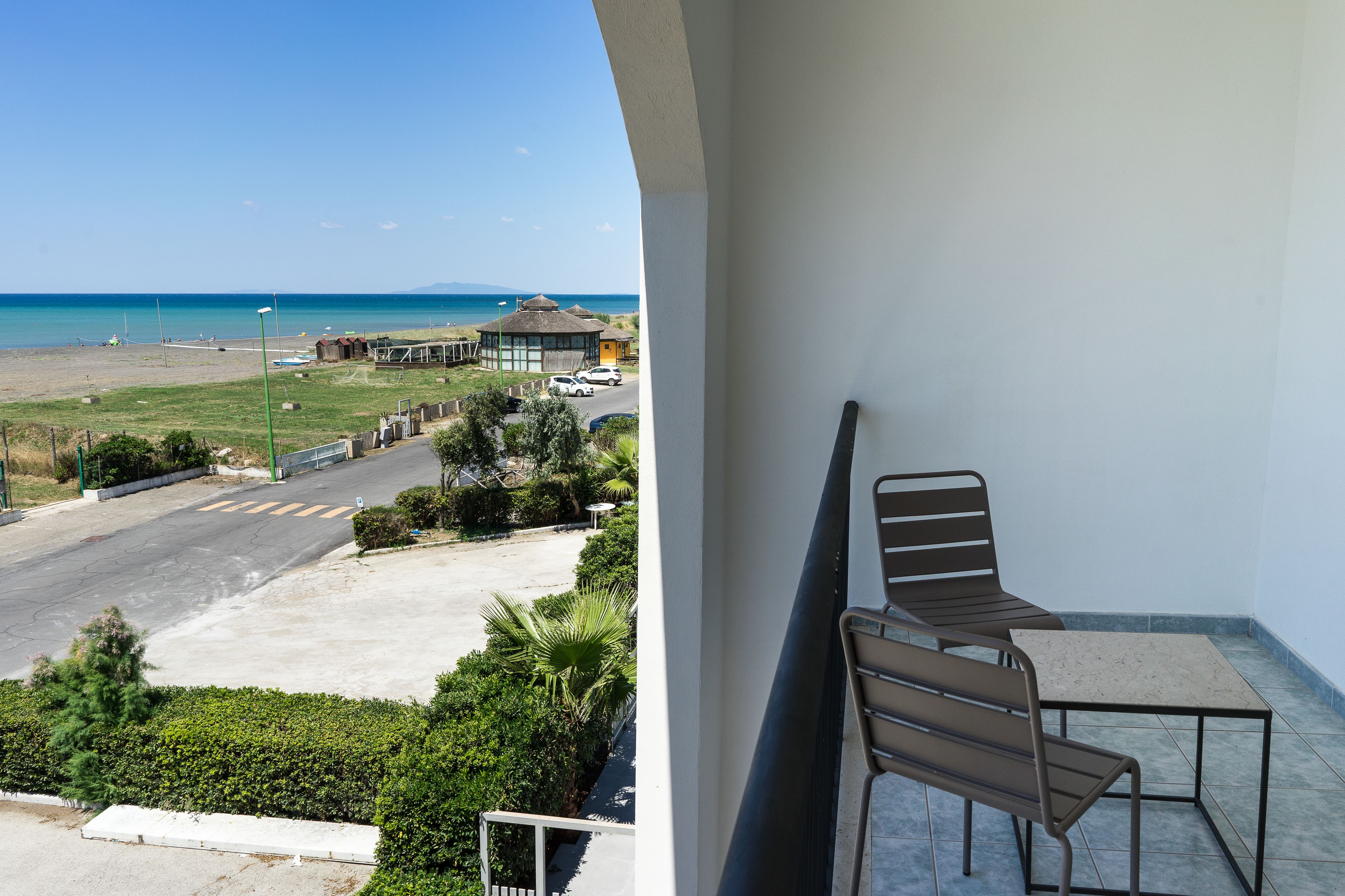 A balcony with a view of the beach and ocean.