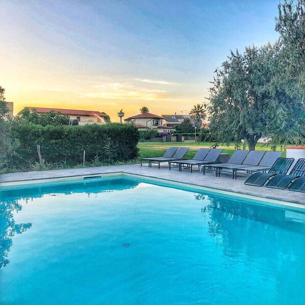 A rectangular swimming pool with clear blue water, surrounded by lounge chairs and a hedge. - Smy Civico Zero (Tarquinia)