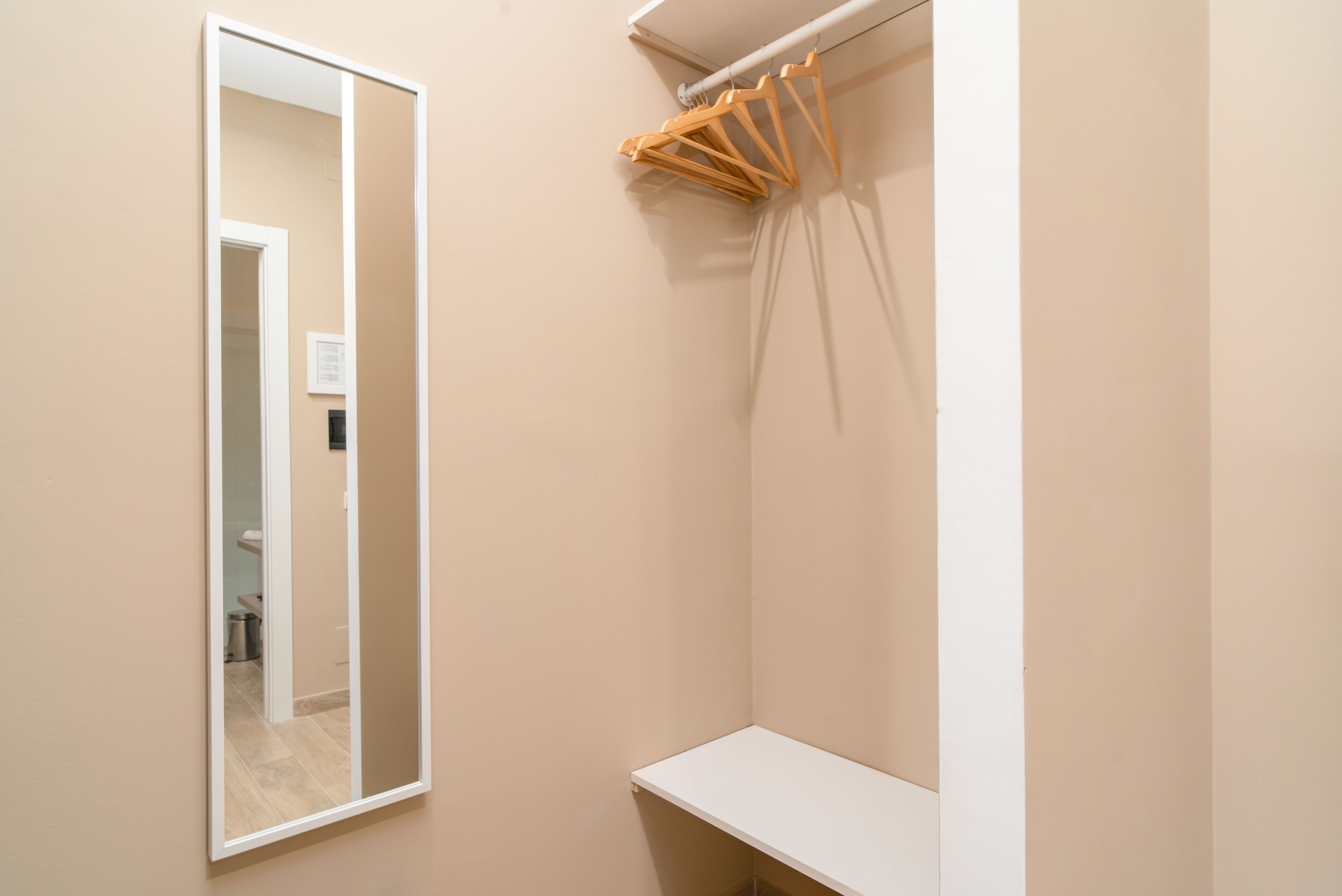 A bathroom with a large mirror, a white sink, and a towel rack.