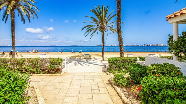 A paved pathway leading to a beach with palm trees and a view of the sea. - 3 bedroom nice apartment in Cartagena (Cartagena)