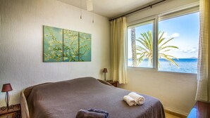 A bedroom with a bed, a painting, a lamp, and a view of the sea. - 3 bedroom nice apartment in Cartagena (Cartagena)