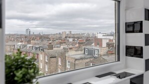 A view from a window overlooking a cityscape with multiple buildings, including residential and commercial structures. - WelcomeStay Clapham Junction 2 bedroom Apartment (London)