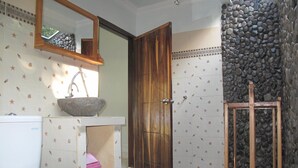 A bathroom with a toilet, sink, and wooden door.