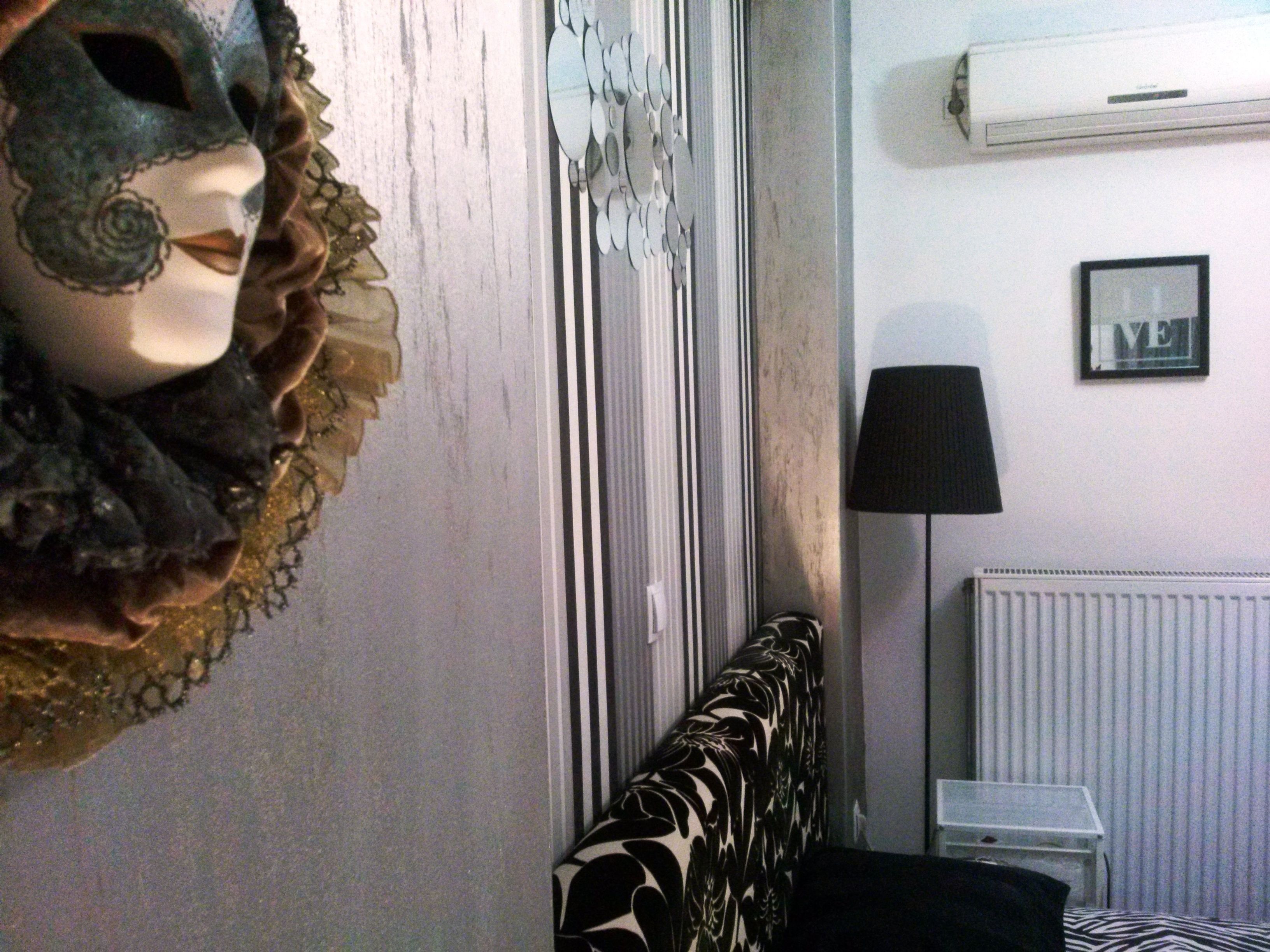 Una habitación con una cama, un radiador, una lámpara y aire acondicionado instalado en la pared.