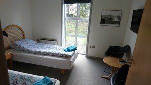 A small, tidy room with a single bed, a chair, a small table, and a window. - Restaurant Vadehavet Mandø (Ribe)
