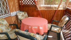 A patio area with a round table covered by a pink tablecloth, surrounded by floral-patterned chairs. - Holiday apartment in a nice area (Cserkeszőlő)