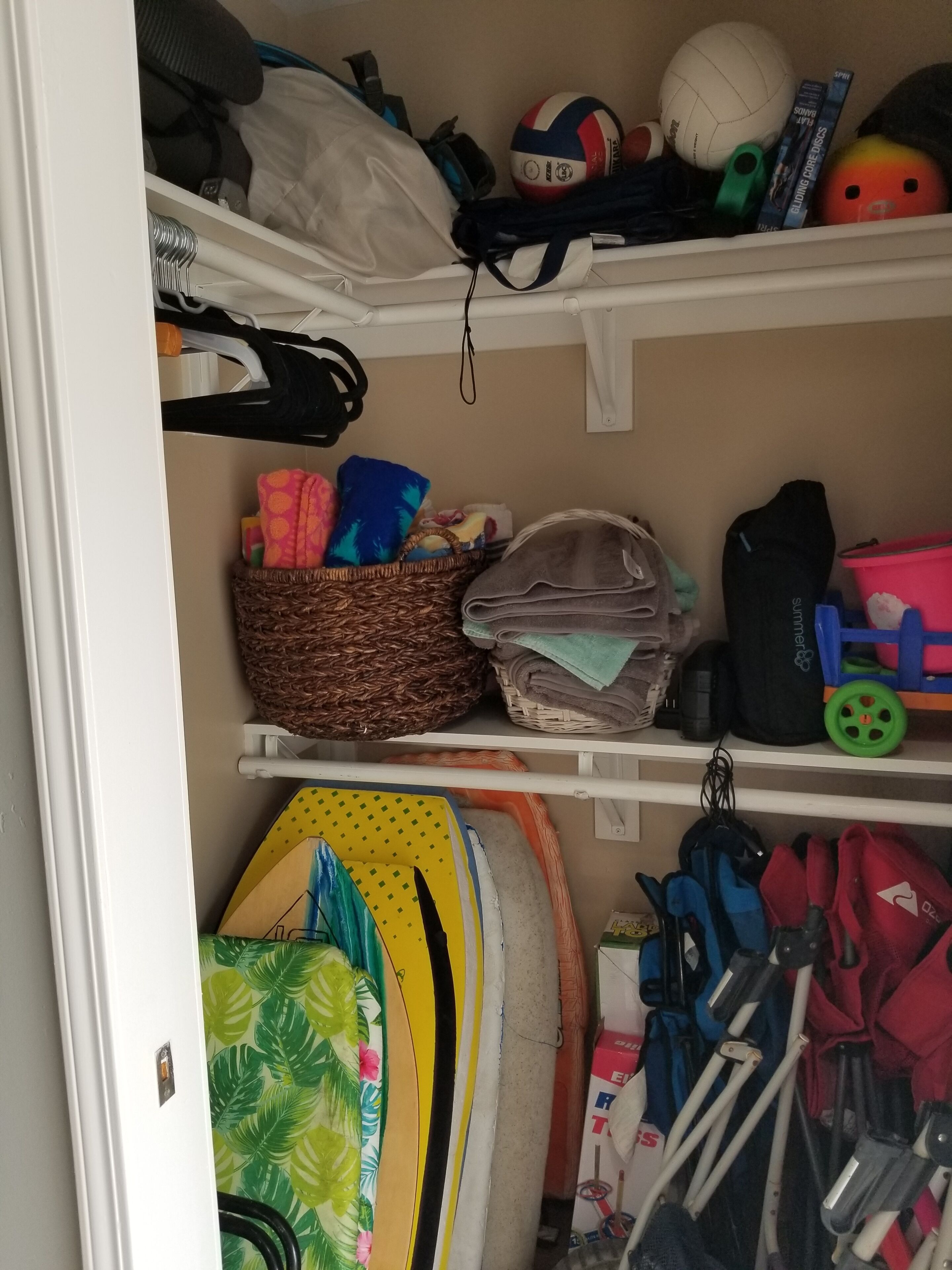 A storage area with shelves containing various items including a volleyball, books, and sports equipment.
