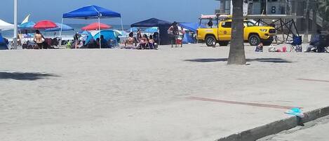 A beach with tents and a lifeguard tower.