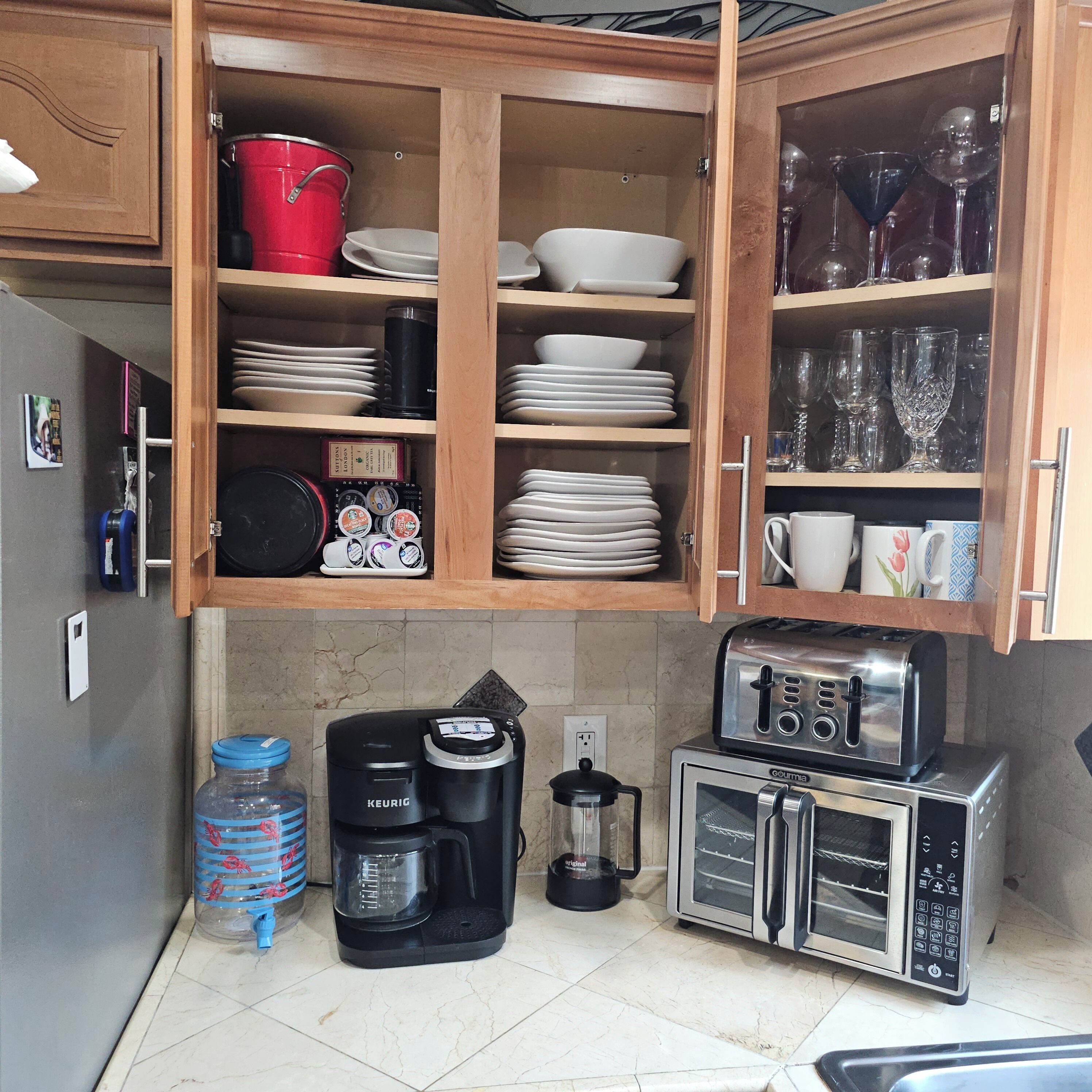 Une cuisine dotée de meubles de rangement en bois, d’une machine à café, d’un grille-pain et de divers ustensiles de cuisine.