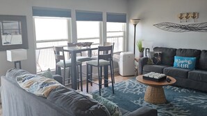 Ein modernes Wohnzimmer mit grauem Sofa, Couchtisch und Balkon mit Blick.