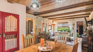 A dining area with a wooden table, candles, and a chandelier. - So. Capitol area quaint casita! Walk to Railyard & Plaza (Santa Fe)