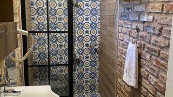 A bathroom with a shower, a sink, and a towel rack.