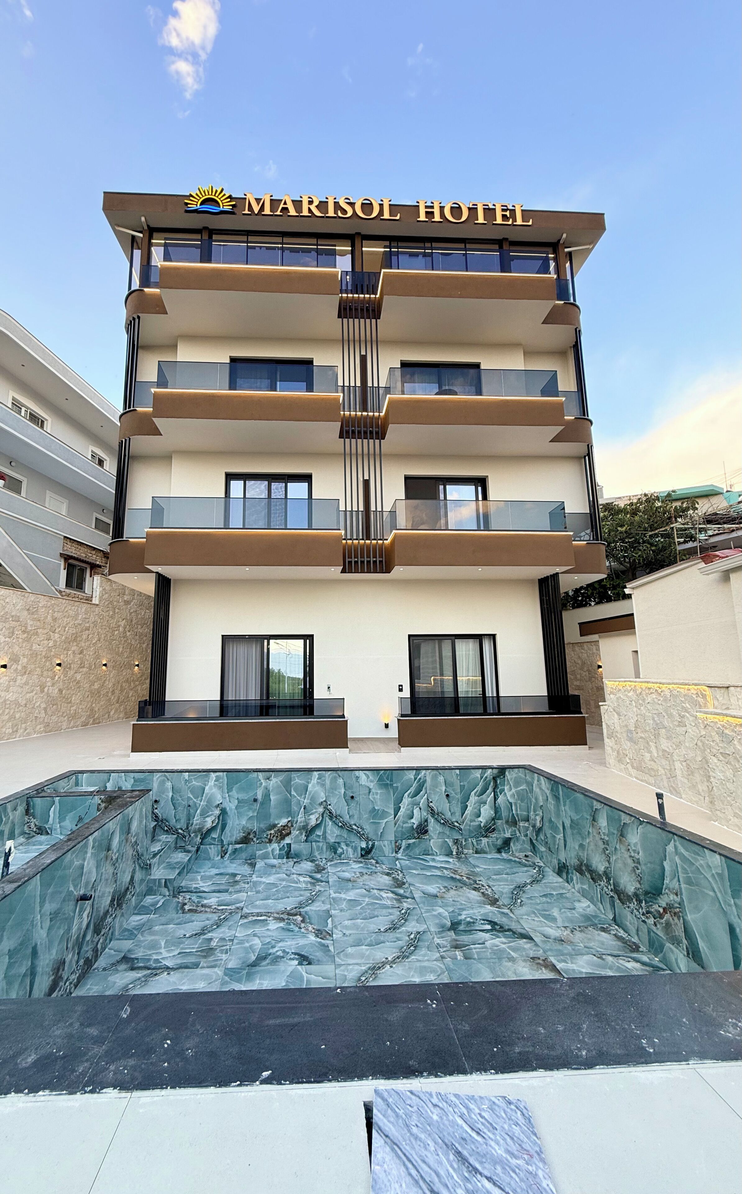 Un hotel de varios pisos con una piscina en frente.