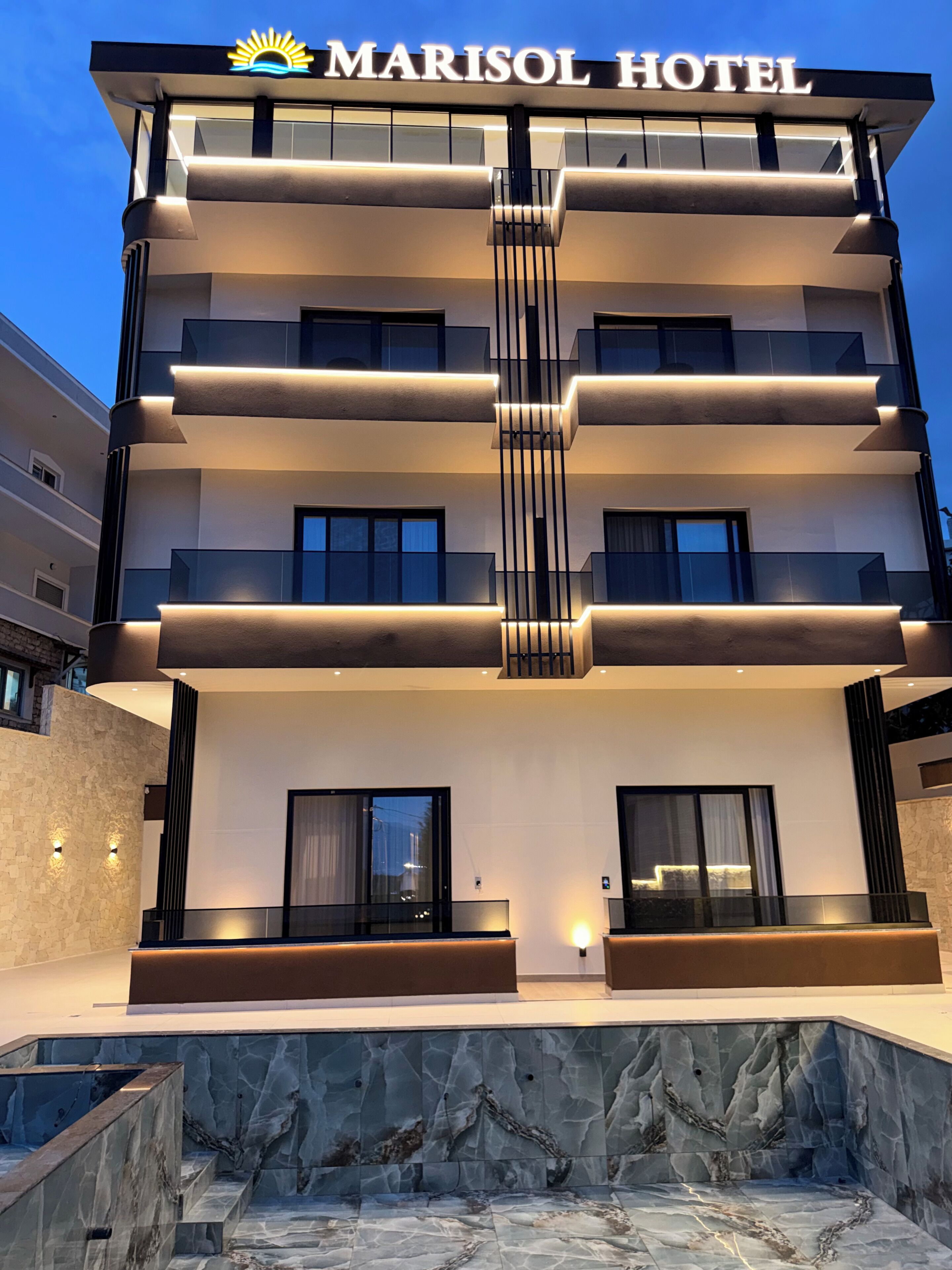 Un Hotel Marisol con diseño moderno, que cuenta con varios balcones y una entrada destacada.