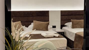 Um espelho grande reflete um quarto com uma cama, almofadas e uma mesa de cabeceira.