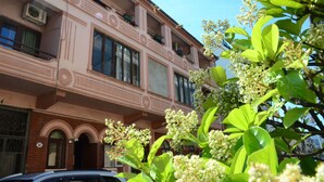 A multi-story building with balconies, large windows, and a brick facade. - Guest House Batumi Globus (Batumi)