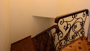 A staircase with a wrought iron railing and a chandelier. - Guest House Batumi Globus (Batumi)