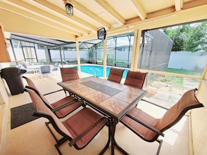 Enjoy meals al fresco at this outdoor dining area with a table and comfortable chairs.