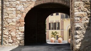 An arched stone bridge with a view of a building with windows and potted plants. - Apartment in renovated farmhouse in typical Chianti Tuscan village (Villa A Sesta)