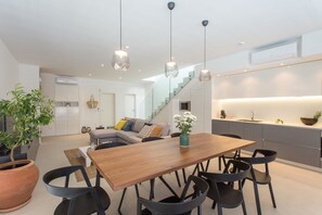 A modern kitchen with a wooden dining table, black chairs, and pendant lights. - Koras Villa - Modern designed villa with heated pool - few steps from the beach  (Kaštel Stari)