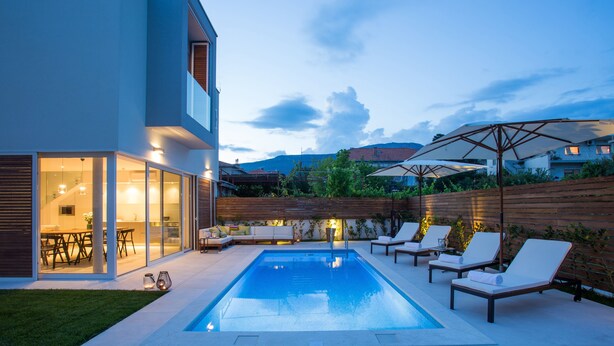 A modern house with a swimming pool, outdoor seating, and a well-lit patio area. - Koras Villa - Modern designed villa with heated pool - few steps from the beach  (Kaštel Stari)